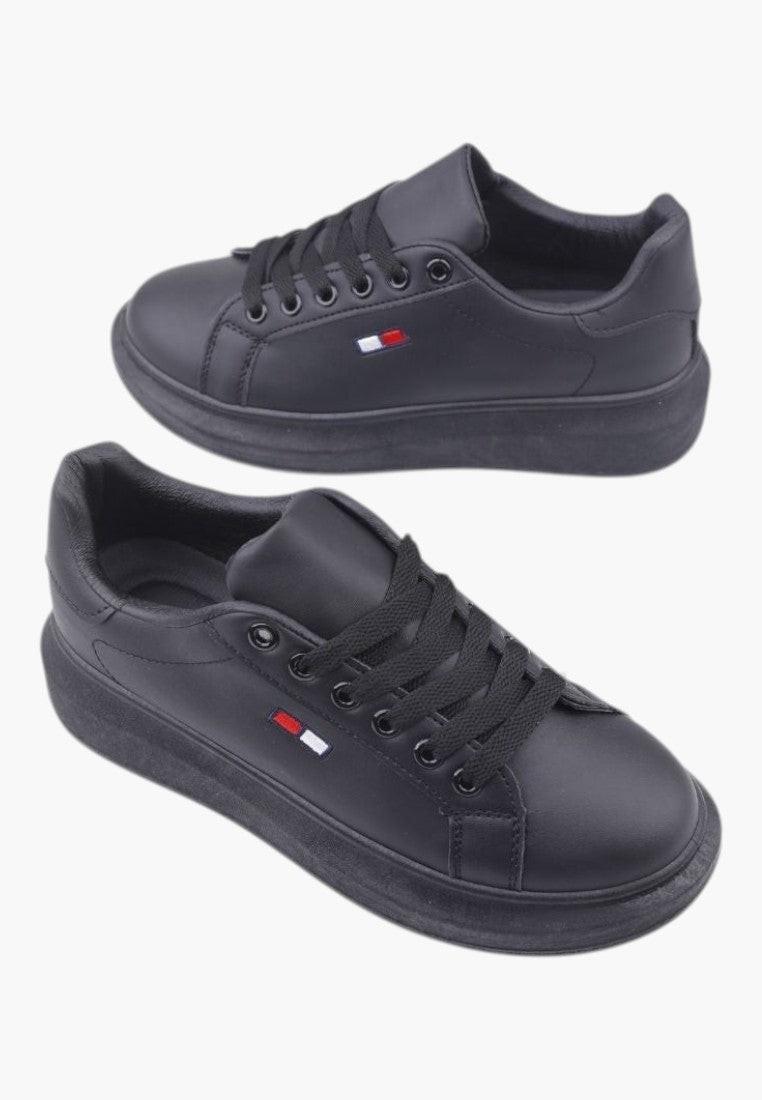 Widok z boku czarnych sneakersów damskich z ekoskóry z detalem logo.