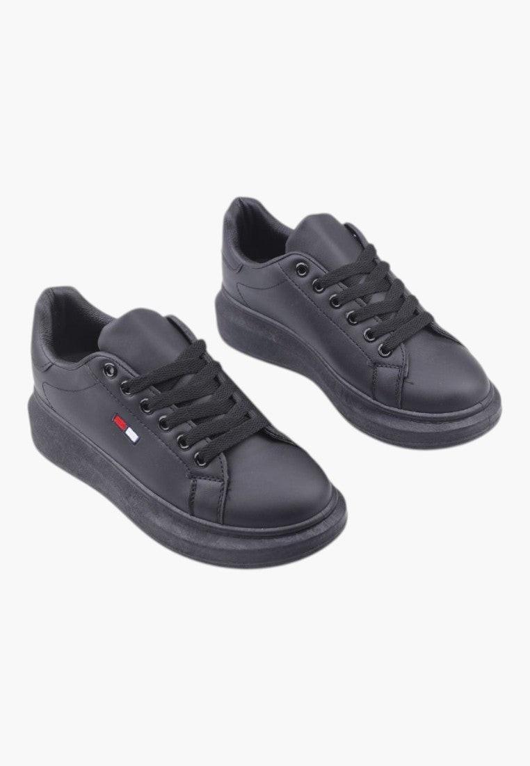 Czarne sneakersy damskie z ekoskóry w stylu życia na białym tle.