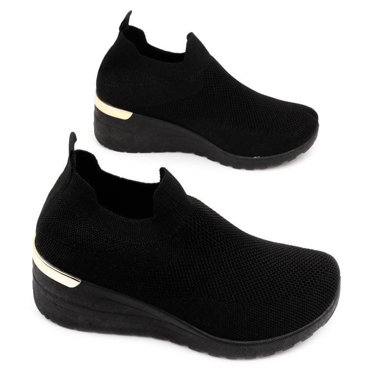 Zbliżenie na detal czarnych sneakersów damskich na koturnie z metaliczną wstawką.
