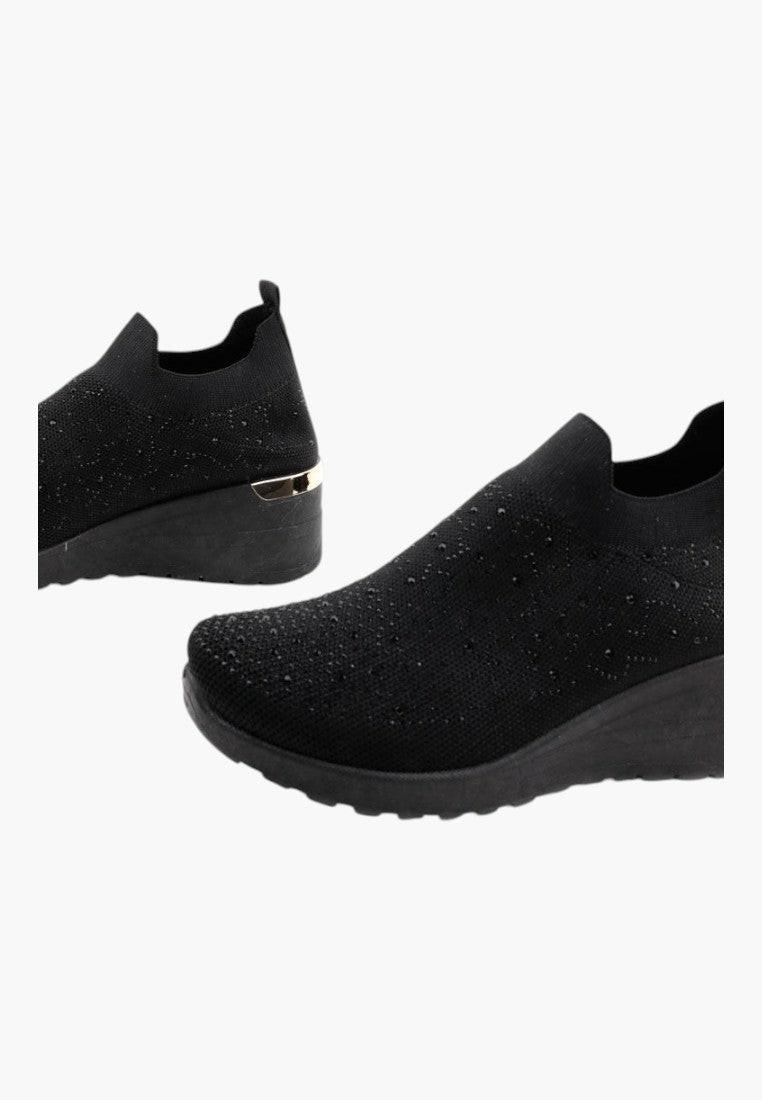 Stylowy profil czarnych sneakersów damskich na koturnie.