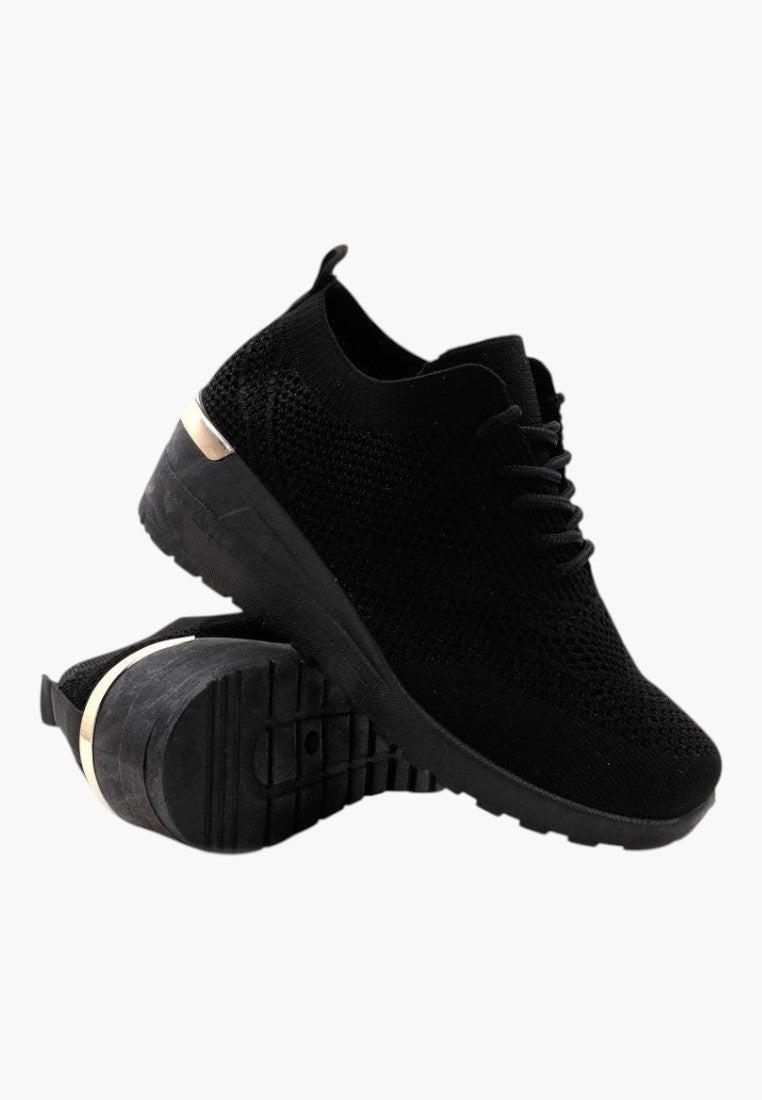 Stylowy design czarnych sneakersów damskich na koturnie w ujęciu lifestyle.