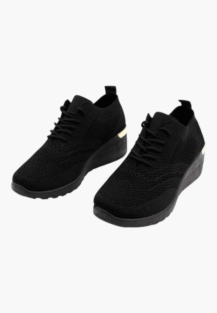 Widok z boku sznurowanych czarnych sneakersów damskich na koturnie.