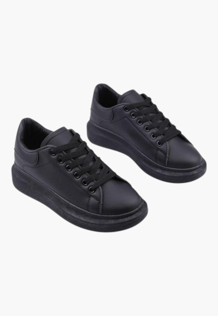 Lifestyle shot of black women's sneakers with lace-up design on a white background