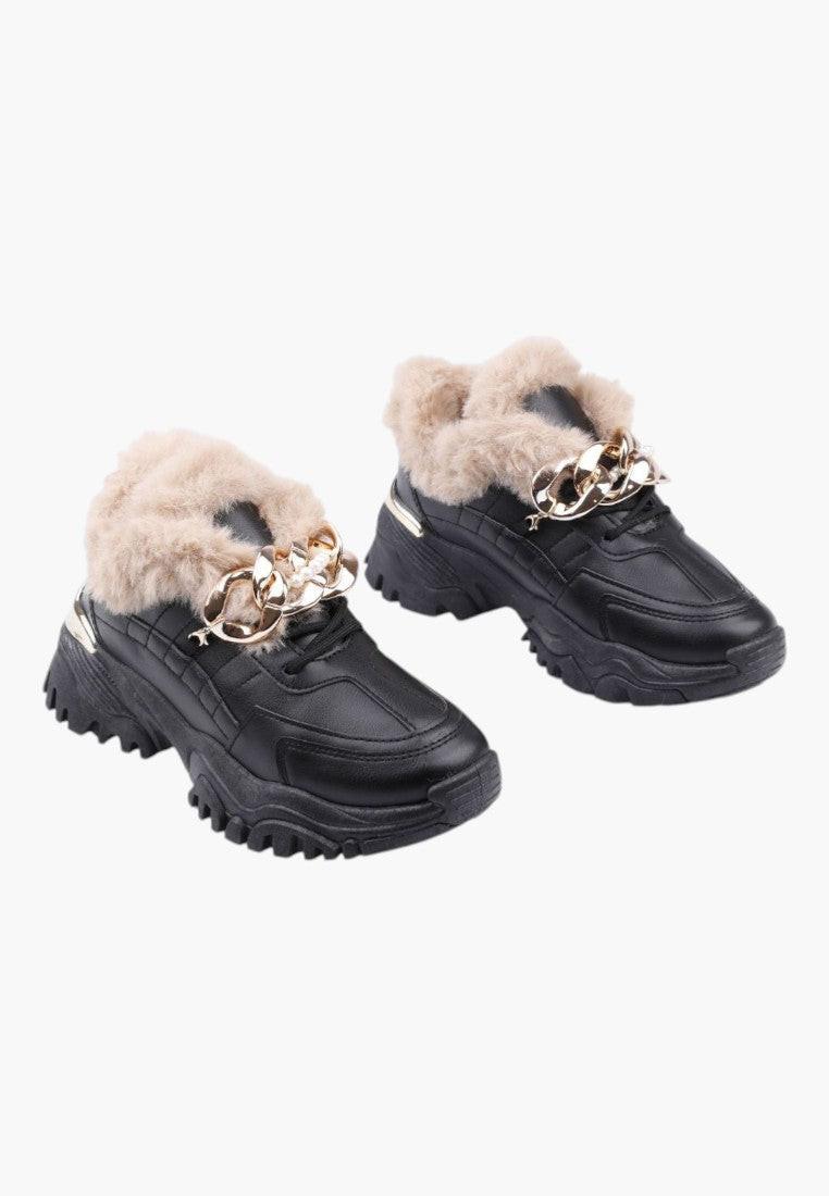 Zbliżenie na sznurowanie czarnych sneakersów damskich z futerkiem.
