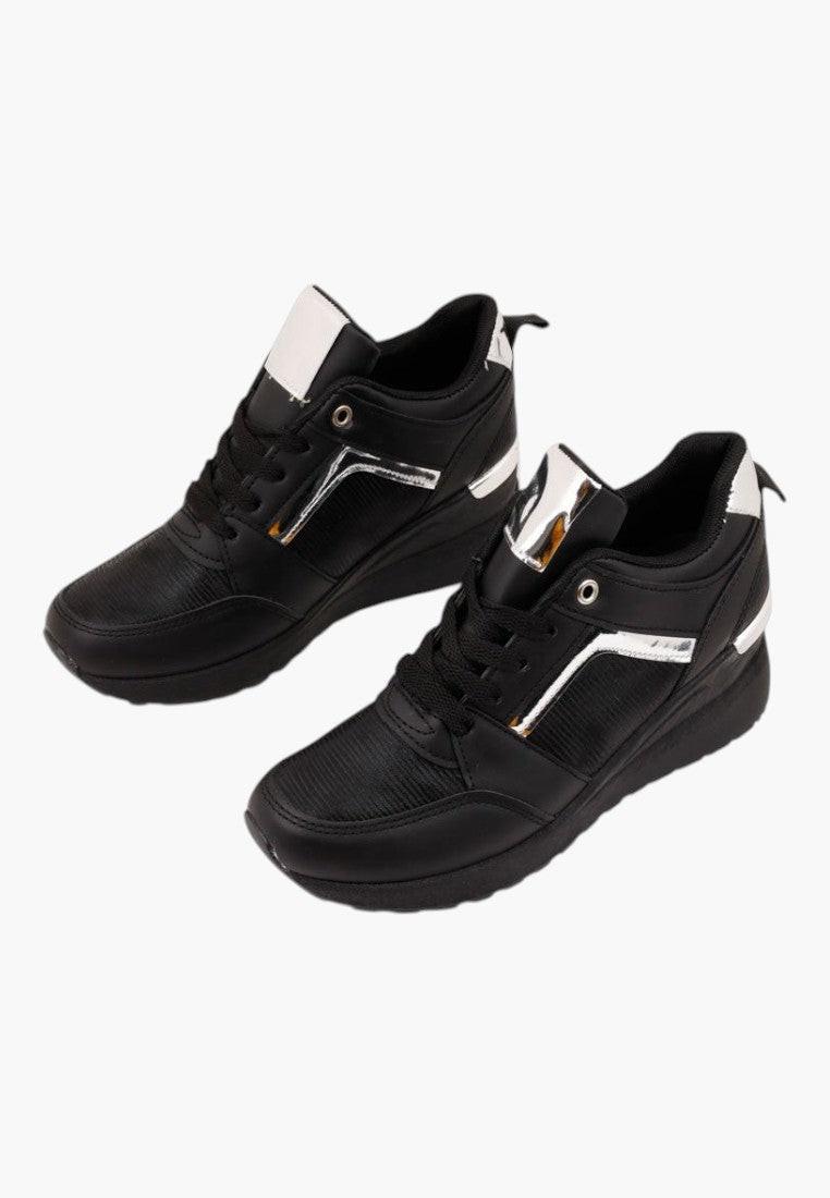 Zbliżenie na teksturowany materiał czarnych sneakersów damskich.