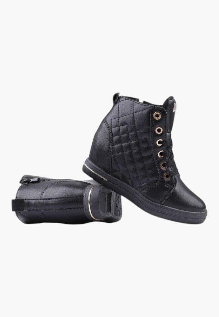 Zbliżenie na teksturowaną powierzchnię czarnych sneakersów damskich.