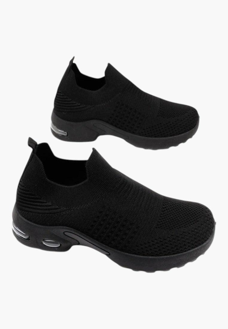 Szczegółowe ujęcie czarnych wsuwanych sneakersów z dzianiny na białym tle