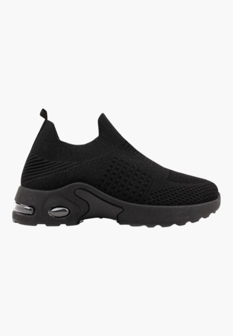 Widok z boku czarnych wsuwanych sneakersów z dzianiny na białym tle