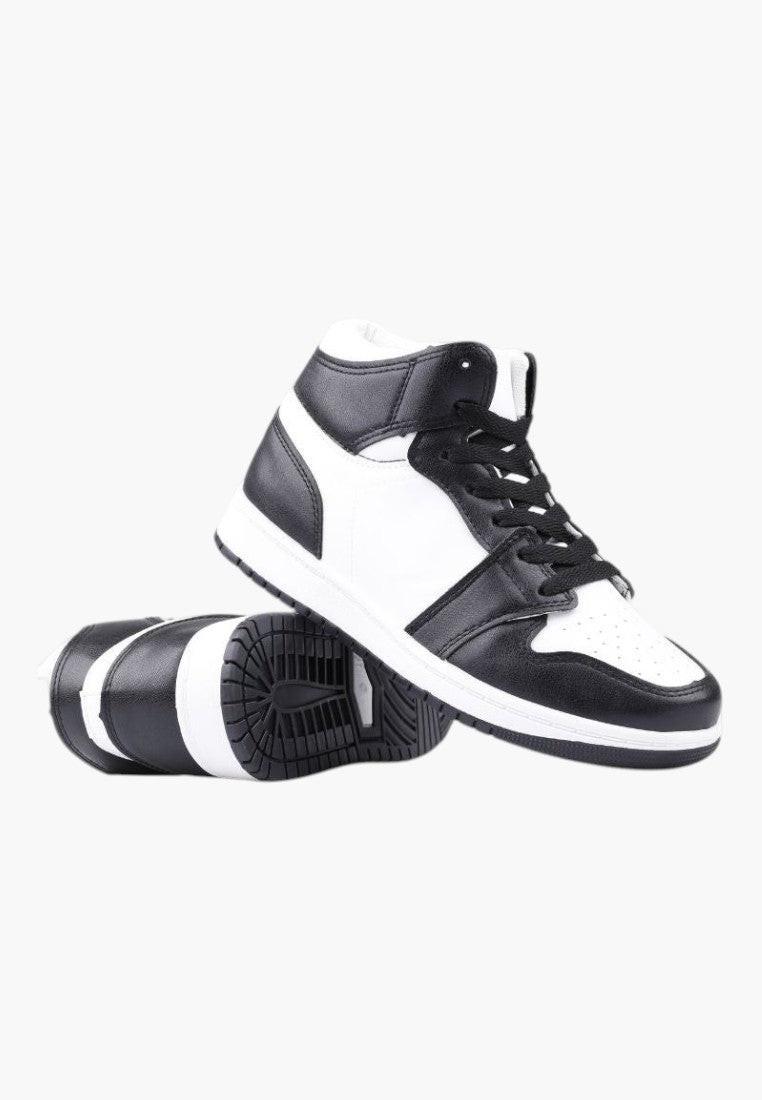 Zbliżenie na detal czarno-białych sneakersów damskich z ekoskóry.