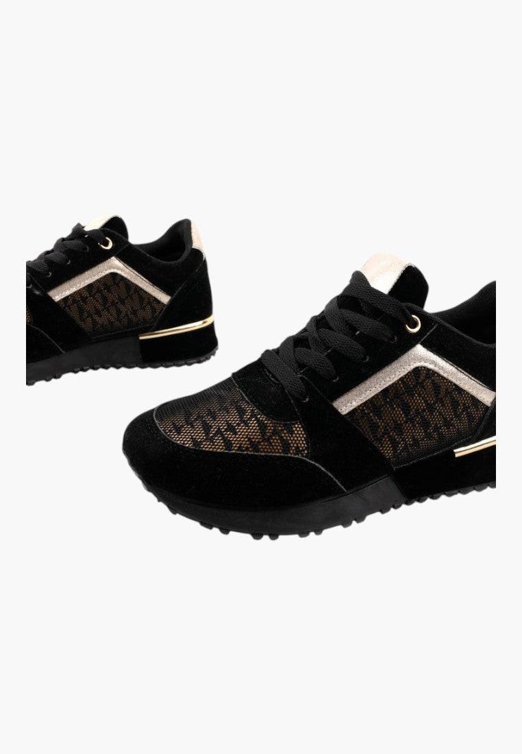 Zbliżenie na teksturowany materiał czarno złotych sneakersów damskich.