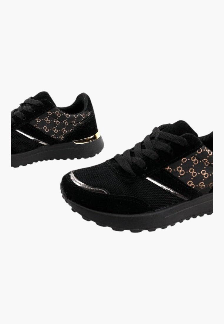 Czarno-złote sneakersy damskie z zamszu, stylowy widok w codziennym otoczeniu.