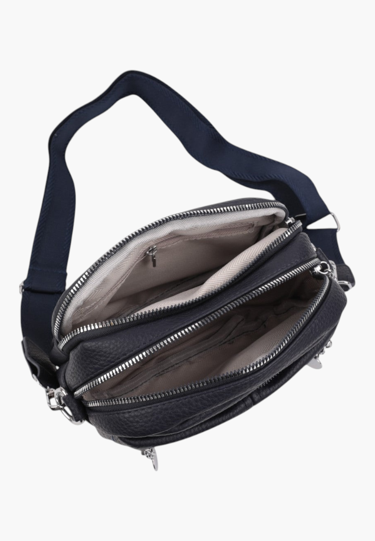 Detail close-up of a black crossbody bag showcasing zipper closure and metal accents on a white background.