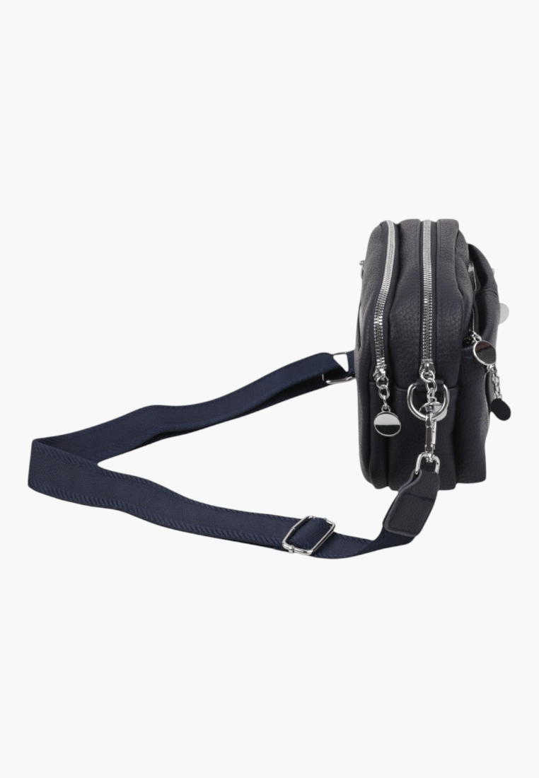 Lifestyle shot of a navy crossbody bag with adjustable strap and open compartments on a white background.