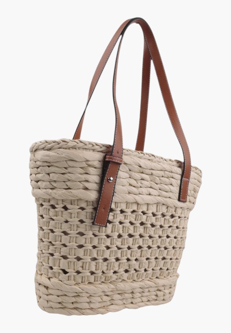 Widok z boku słomkowej torebki shopper w kolorze beżowym i brązowym z plecionym wzorem.
