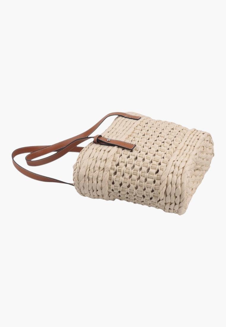 Zbliżenie na plecioną torebkę shopper w kolorze beżowym i brązowym.