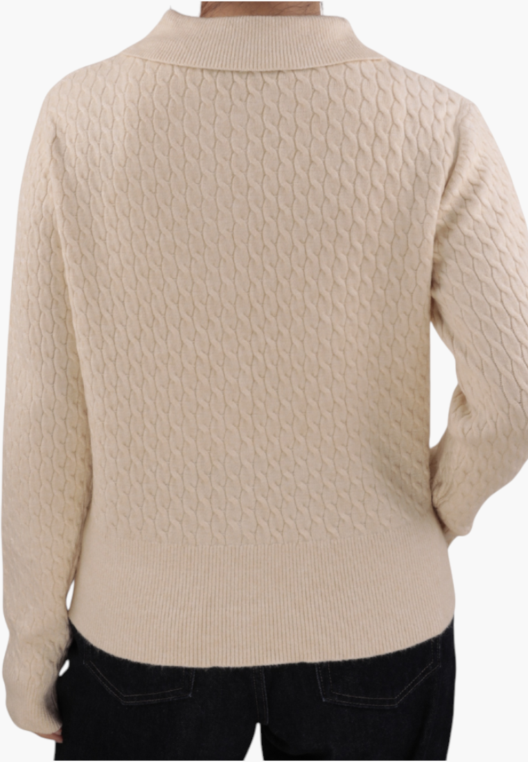 Falio beige cable knit button-up cardigan with long sleeves and a round neckline worn by a woman