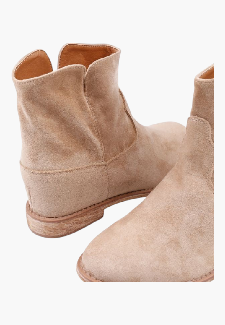 Falio beige faux suede ankle boots with a hidden wedge heel and rounded top, perfect for a western-inspired look.