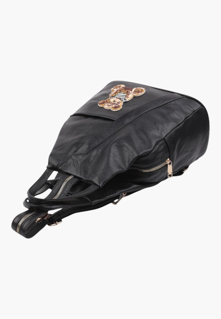 Falio small black urban backpack made of eco-leather with a decorative bear patch and secure zipper closure