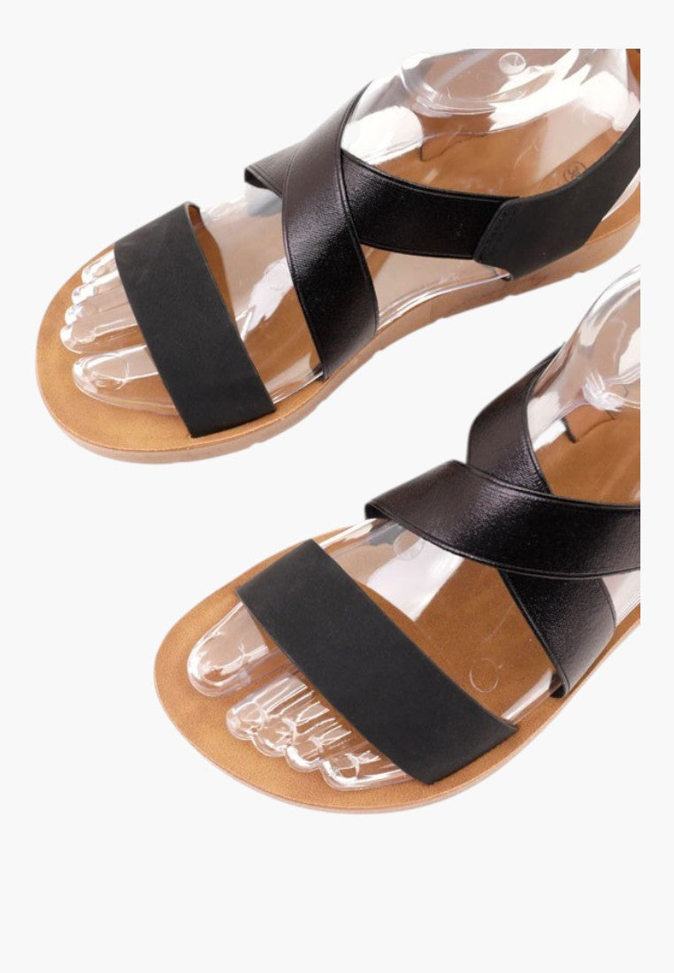Falio black slip-on sandals with crisscross straps, open toe, and thick sole made of faux leather and rubber