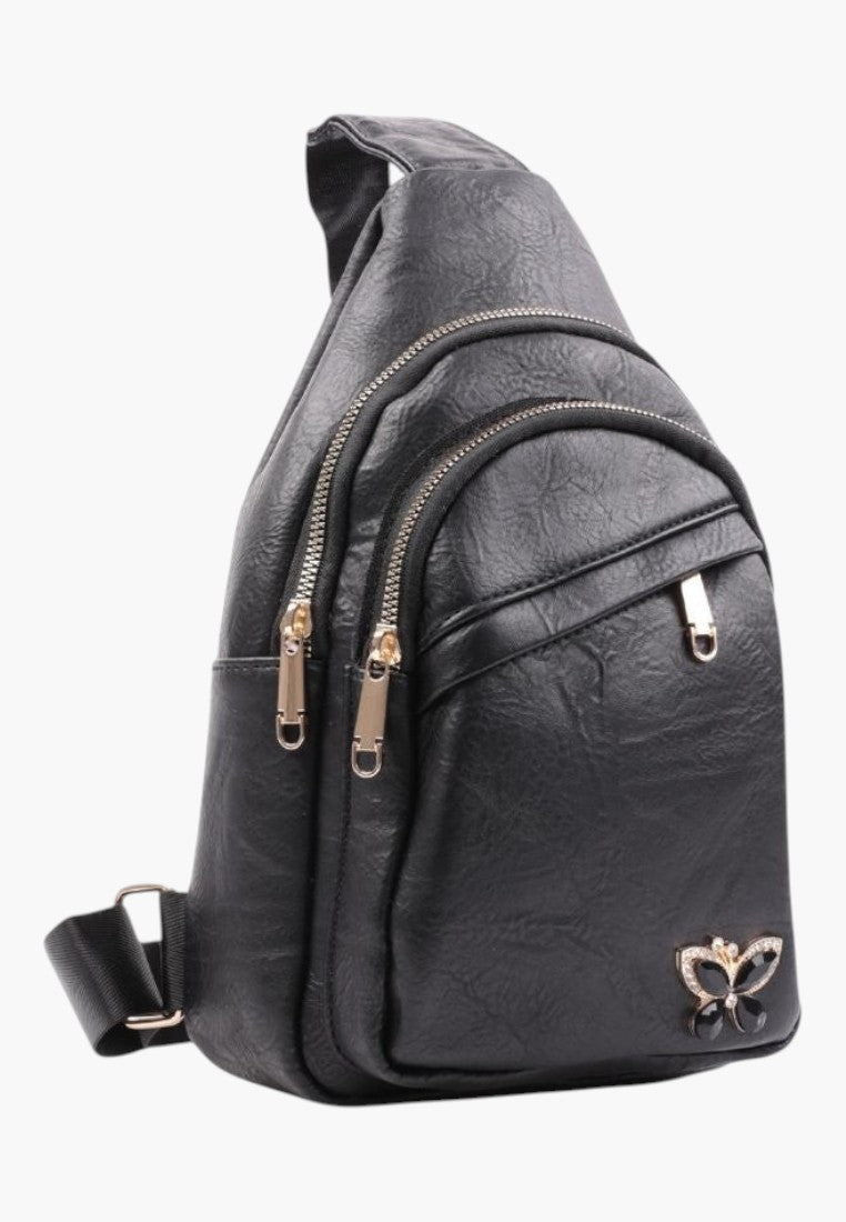 Falio black faux leather urban sling backpack with multiple zippered pockets and a decorative butterfly emblem