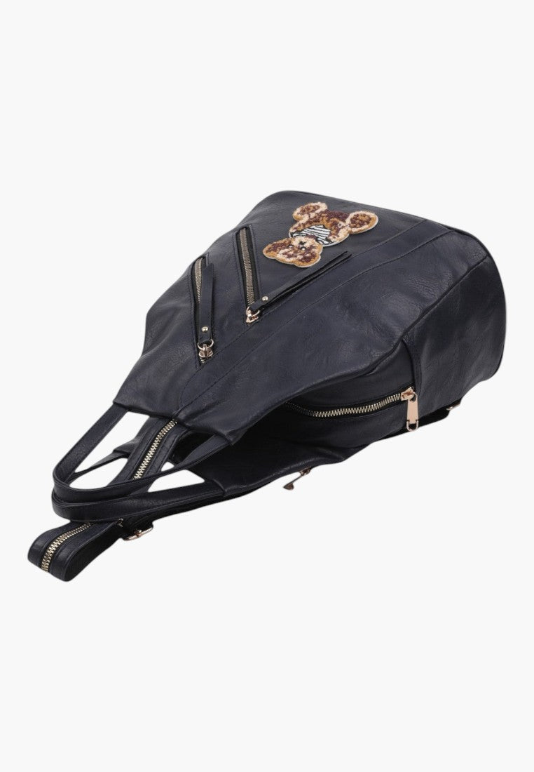 Falio black faux leather urban backpack with a decorative teddy bear patch and multiple zippered pockets.
