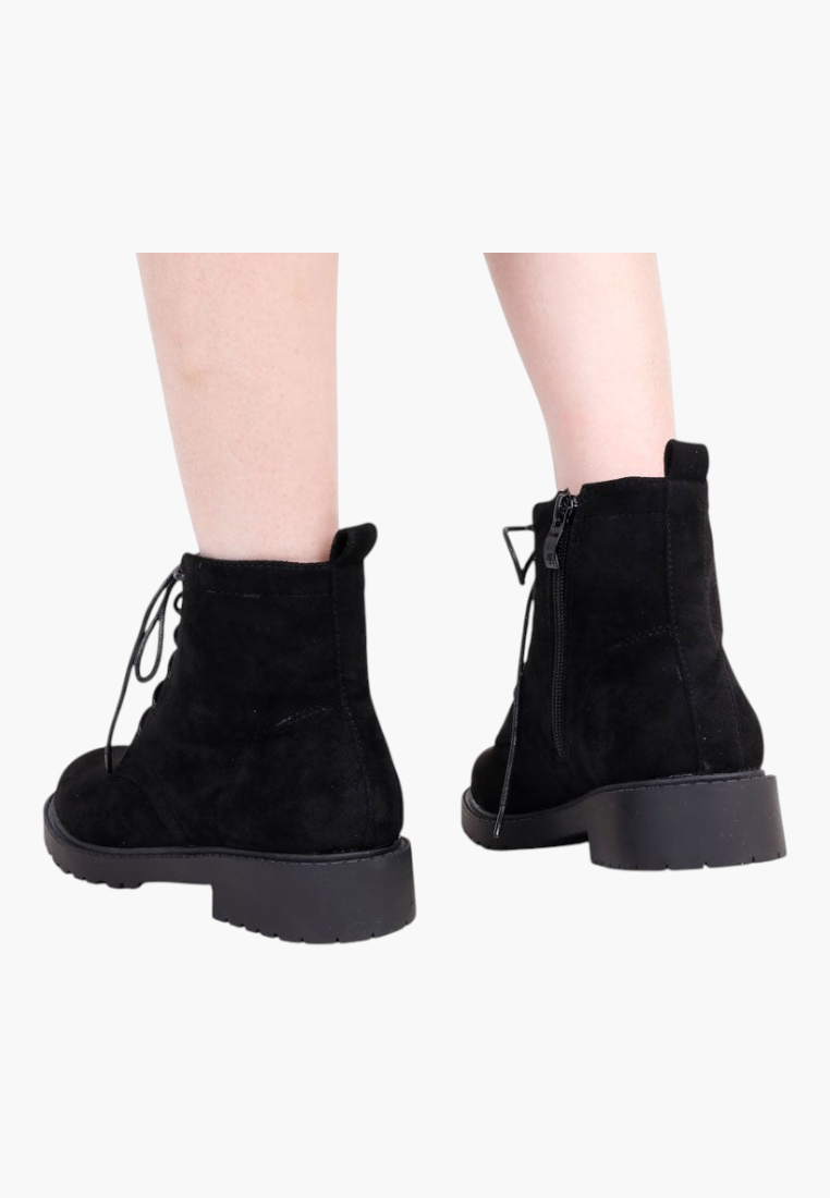 Falio black faux suede ankle boots with flat soles, side zippers, and front laces, shown from the back