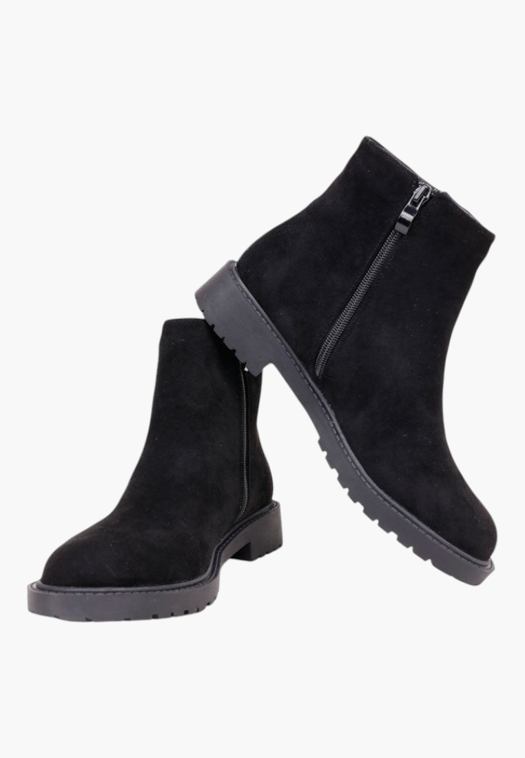Falio black faux suede ankle boots with a round toe, side zipper, and flat lug sole for winter wear.
