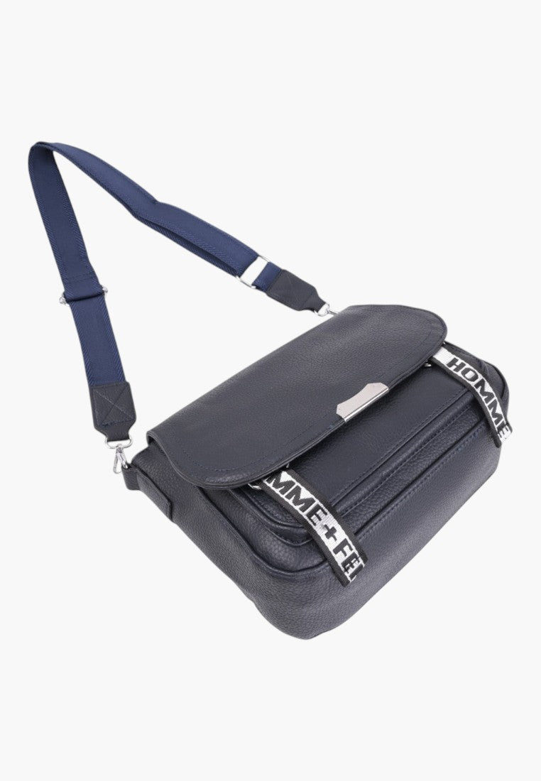 Falio blue faux leather crossbody bag with a flap, adjustable strap, and branded webbing detail.