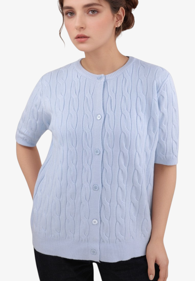Model wearing a light blue Falio short-sleeve viscose cable knit cardigan with a round neckline and button front.