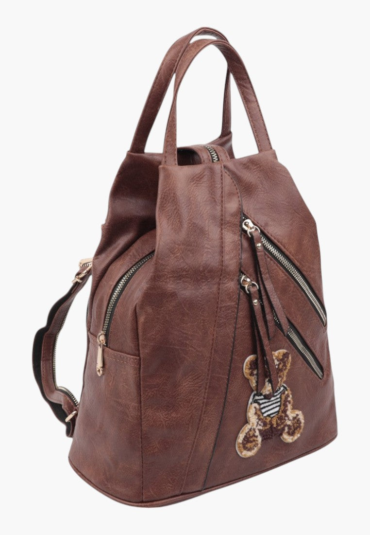 Falio brown faux leather urban backpack with multiple zippered pockets and a cute bear patch detail