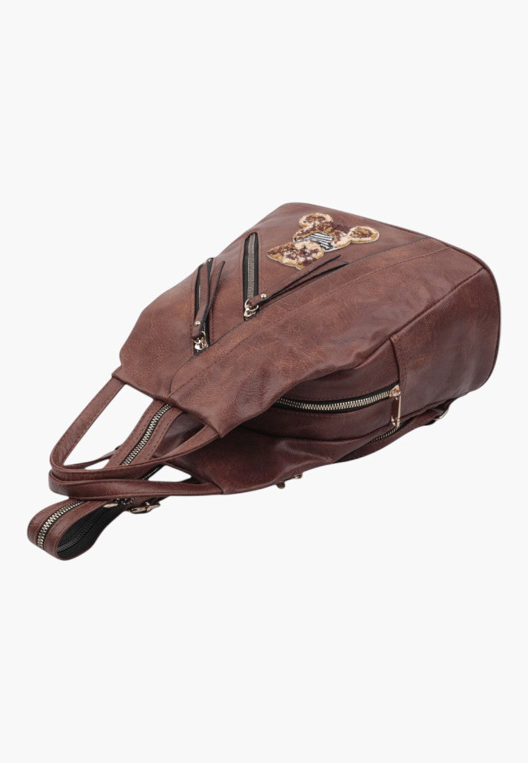 Falio brown faux leather urban backpack with a decorative bear patch and multiple zippered pockets