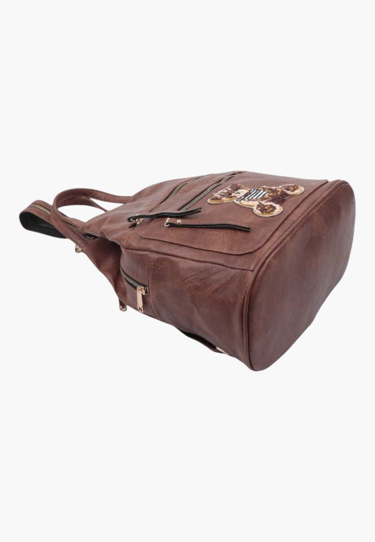 Falio brown faux leather urban backpack with a decorative teddy bear patch and multiple zippered pockets