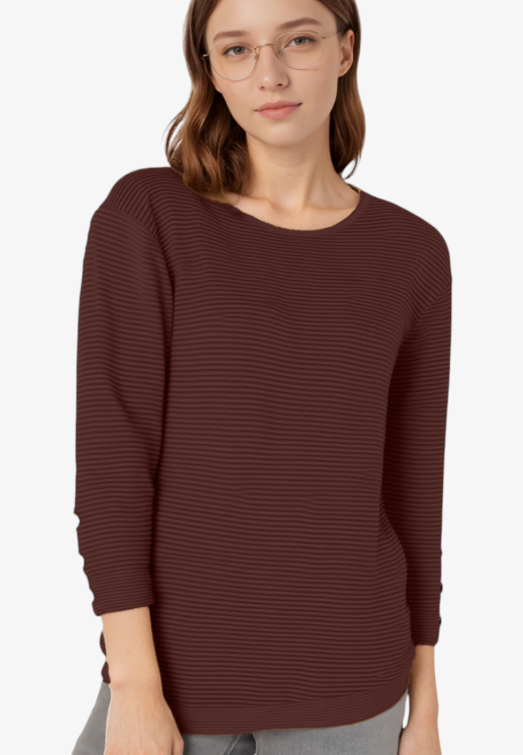 Falio woman wearing a dark brown ribbed long-sleeve sweater with a round neckline, studio shot on white background.