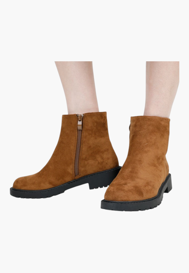 Falio brown suede ankle boots with a side zipper and chunky black lug sole worn on feet