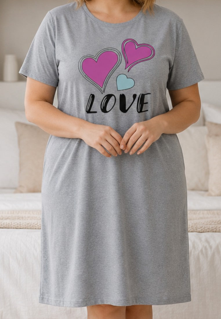 Falio grey cotton nightshirt with pink and blue heart print and LOVE text worn by a smiling woman in a bedroom
