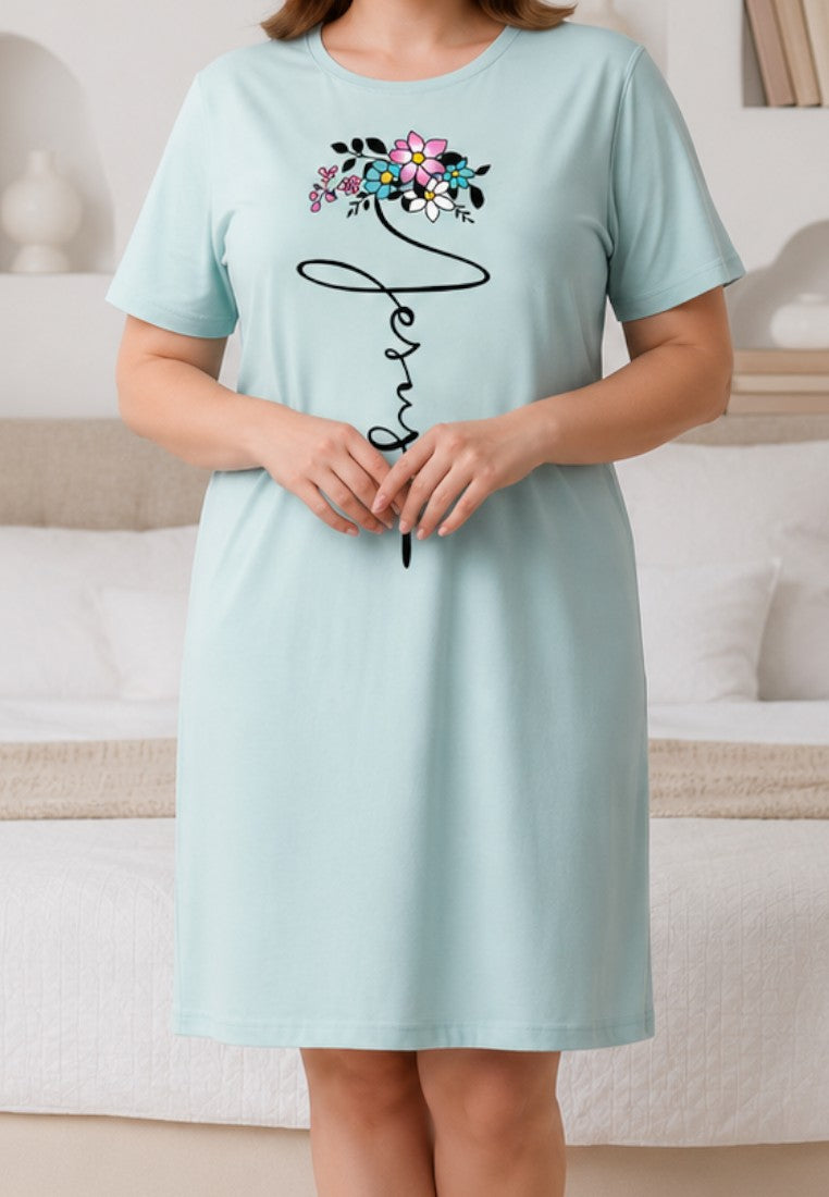 Falio light blue short-sleeve nightgown with floral Jesus script graphic worn by a woman in a bedroom.