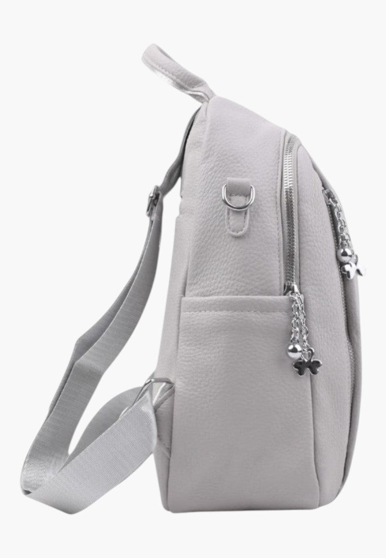 Falio light grey faux leather urban backpack with side pockets and silver zipper charms, side view