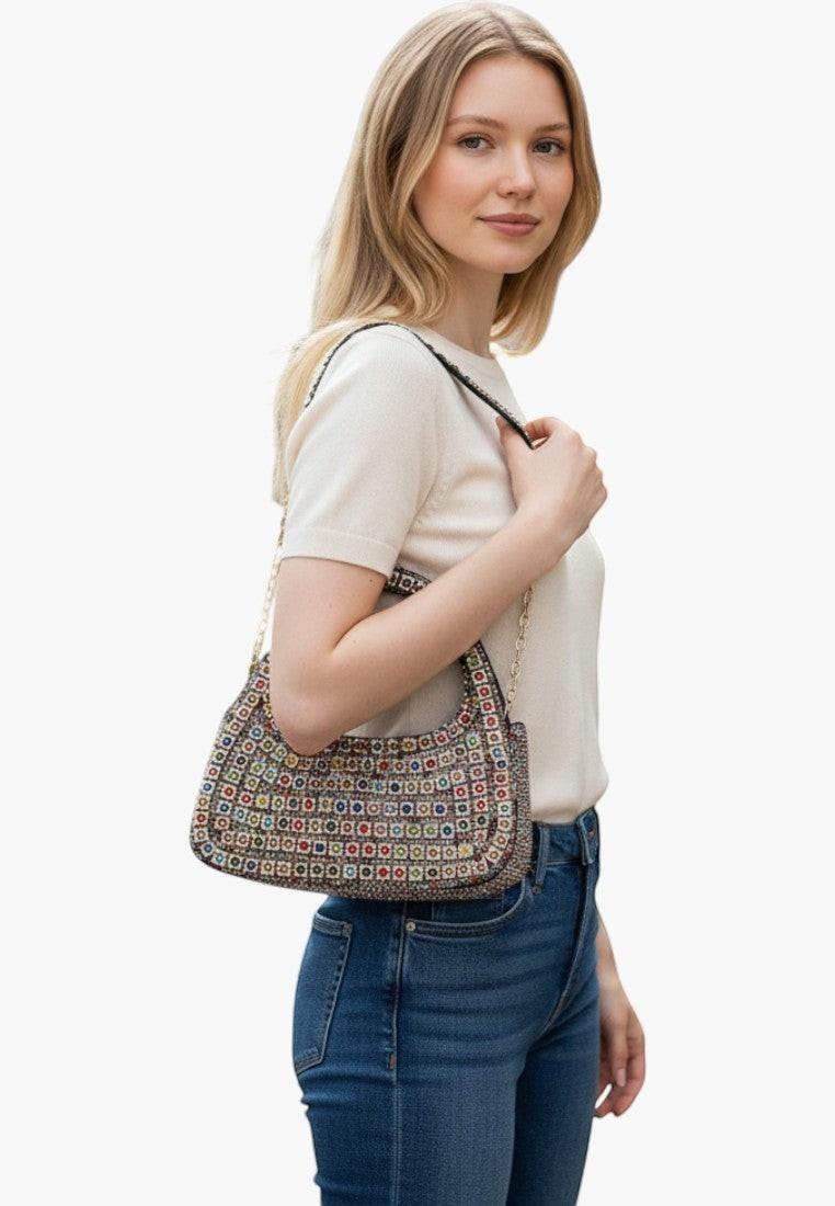Falio multicolor beaded evening bag with zip closure and phone pocket, worn by a woman in jeans and a cream top.
