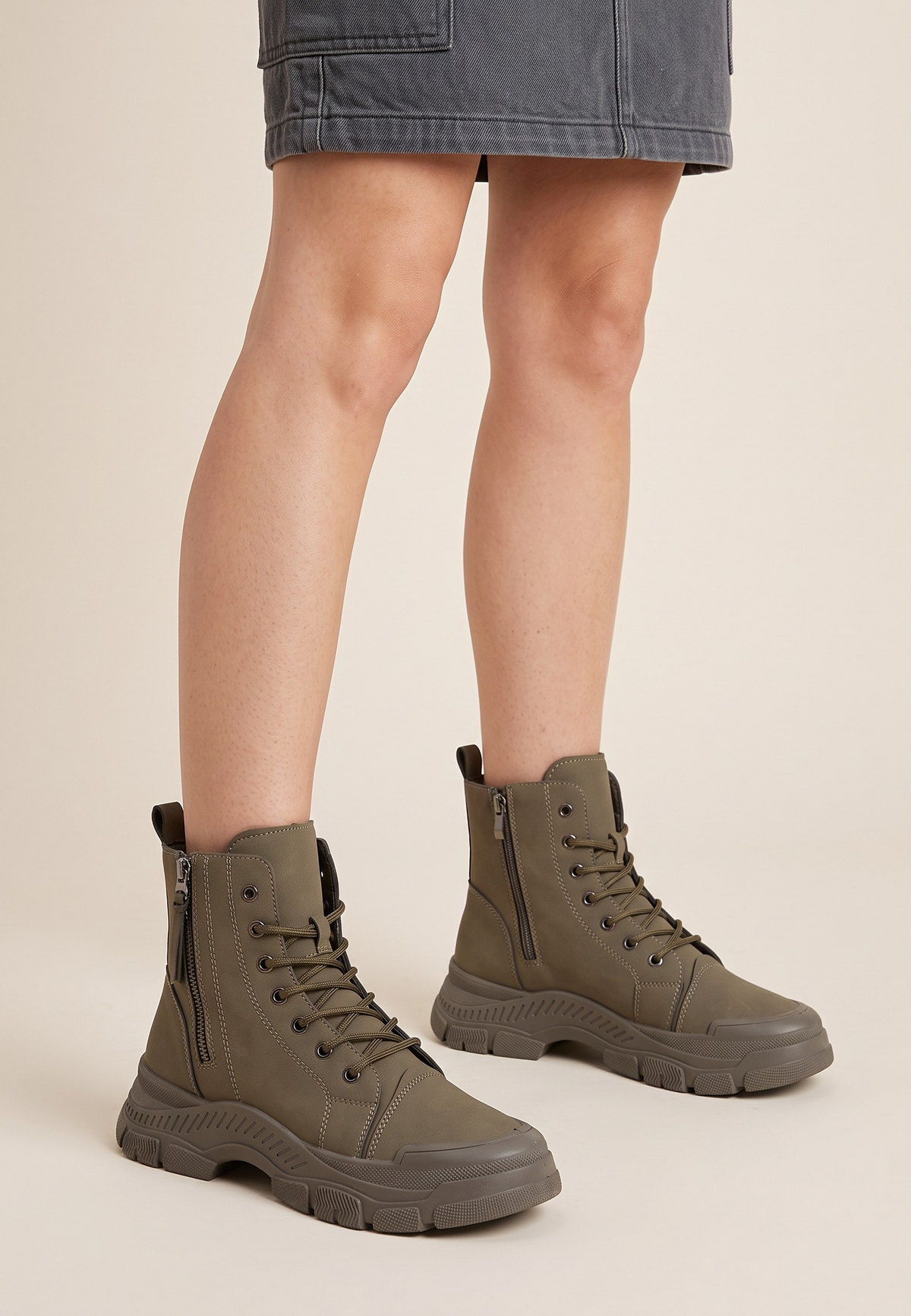 Falio olive green synthetic nubuck lace-up ankle boots with chunky lug soles worn with a grey denim skirt