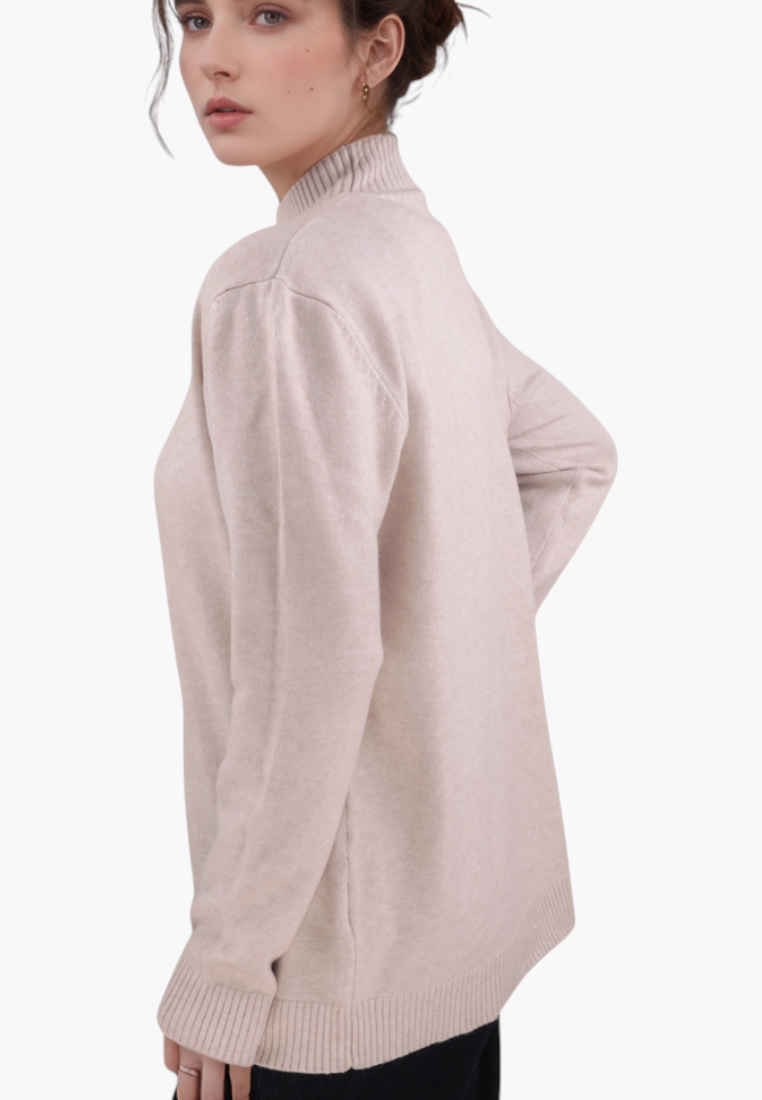 Falio plus size beige long-sleeve sweater with a mock neck, worn by a woman, side view.
