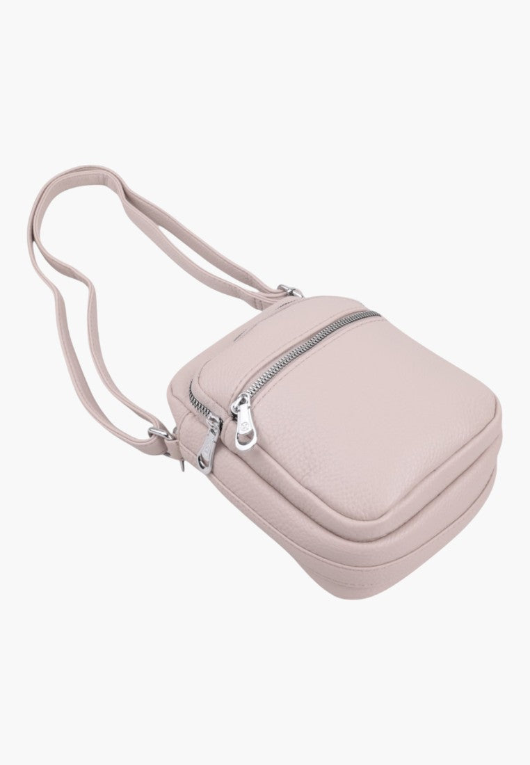Falio small light pink faux leather crossbody bag with a zippered front pocket and adjustable shoulder strap