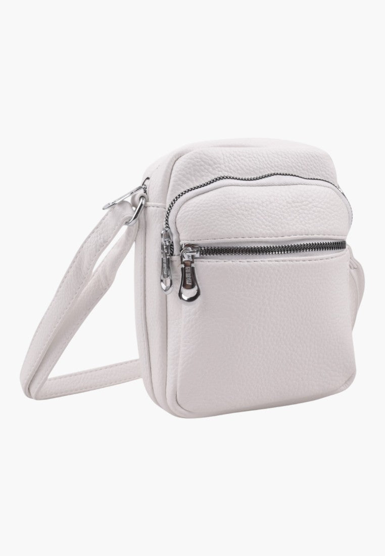 Falio small white faux leather crossbody bag with zippered compartments and an adjustable shoulder strap.