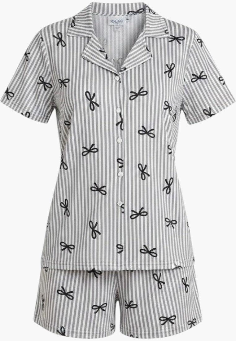 Falio women's two-piece pajama set with grey and white stripes and black bow print. Features short sleeves, collar, button-up top, and short bottoms. 100% cotton.