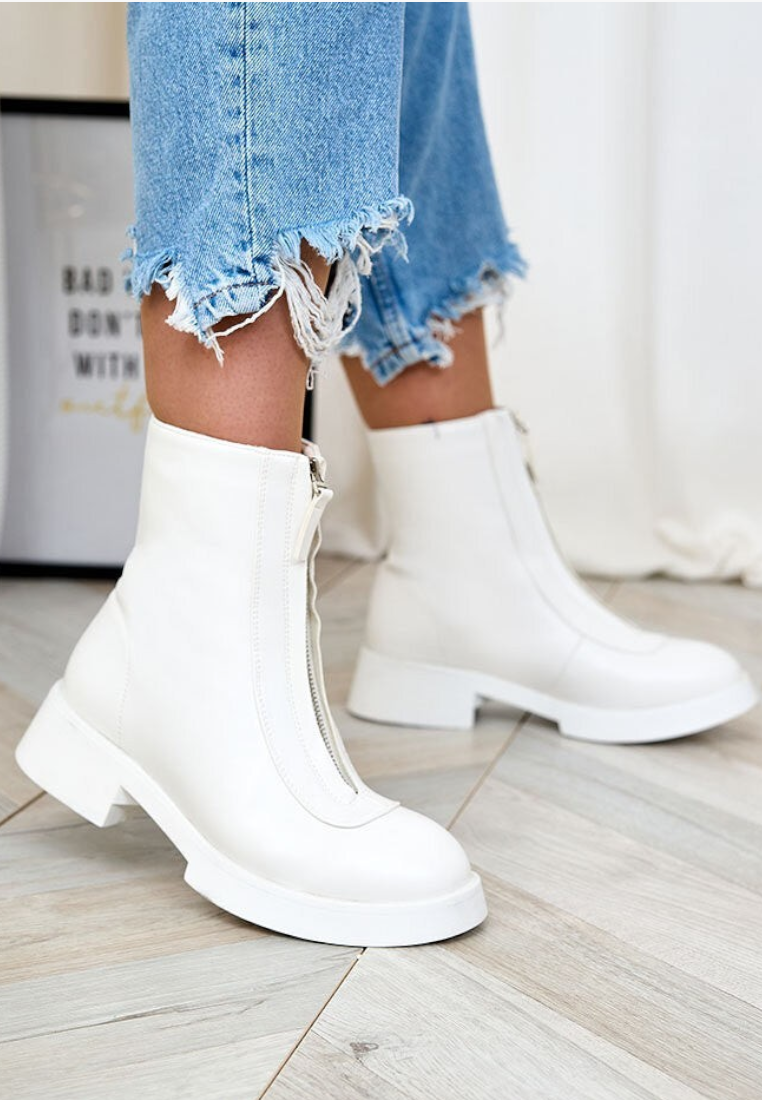 Falio white insulated ankle boots for women with a front zipper closure and chunky sole, worn with distressed jeans.