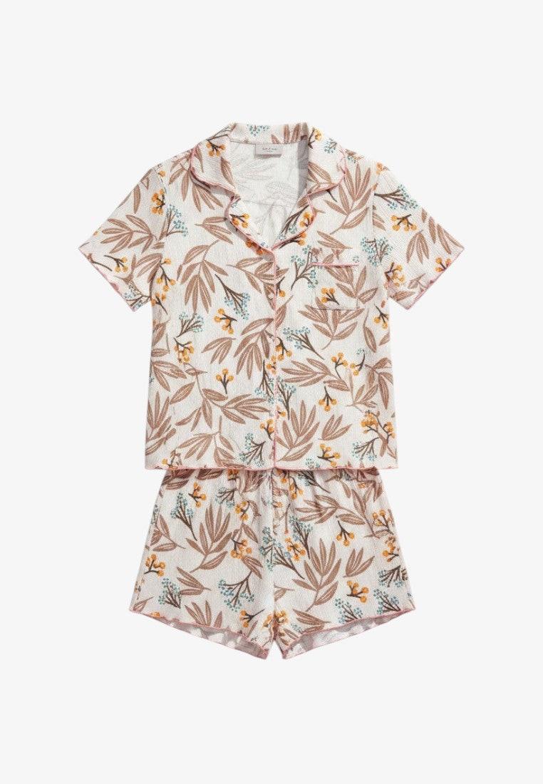 Falio women's 100% cotton pajama set with a floral print in white, brown, and yellow. Features a collared top and shorts with pink trim.