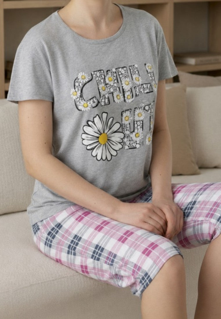 Falio women's cotton pajama set with grey graphic t-shirt and pink plaid capri pants, worn by a smiling woman.