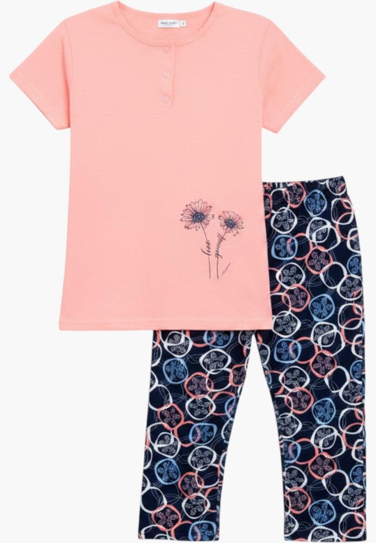Falio women's peach cotton pajama set with short sleeves, round neck, button closure, and navy capri pants with a circular floral pattern.