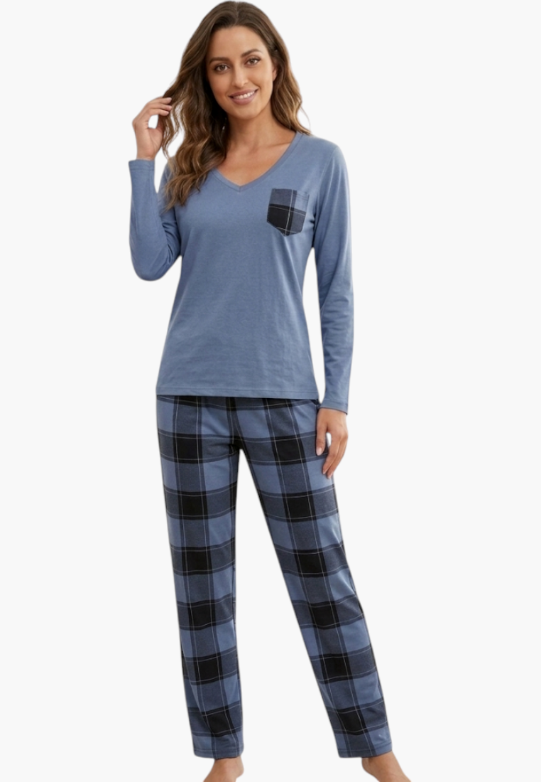 A woman wearing a Falio cotton pajama set with a blue long-sleeve top and blue and black plaid flannel trousers.