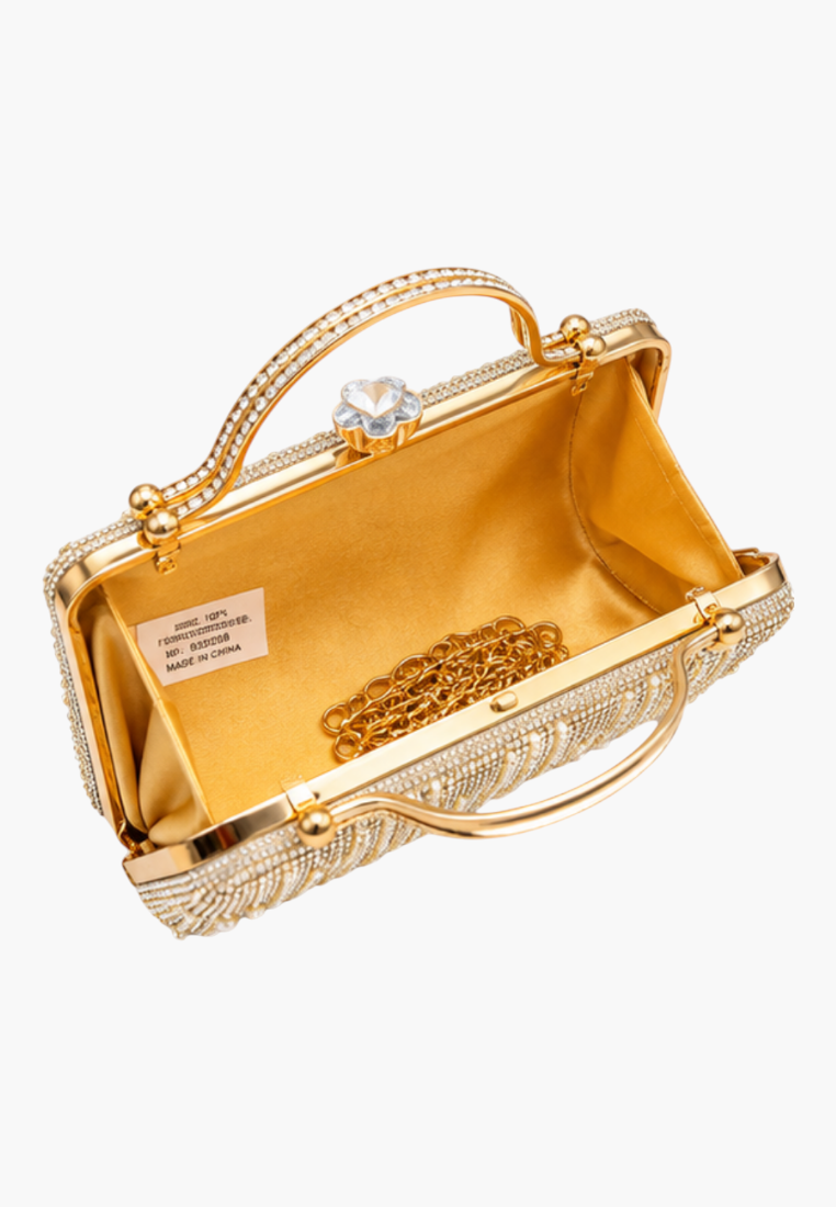 Close-up detail of the gold handbag with ornate design and chain strap.