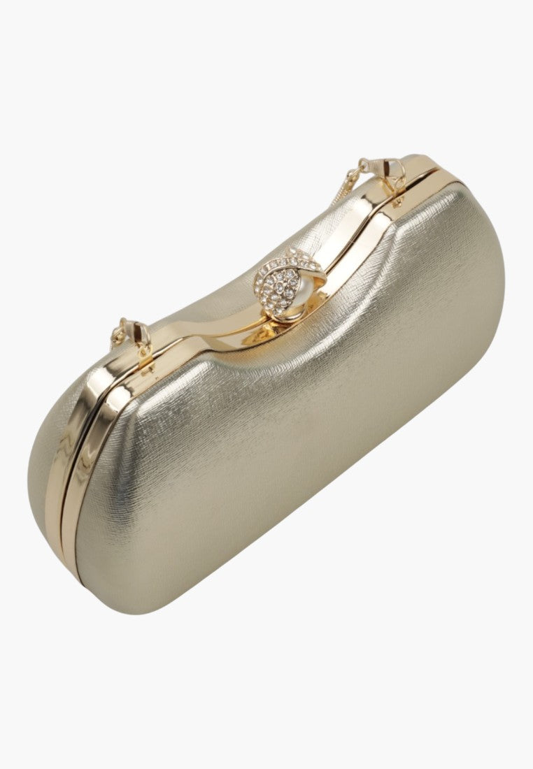 Detail view of a silver handbag showcasing gold hardware and a curved design on a white background.
